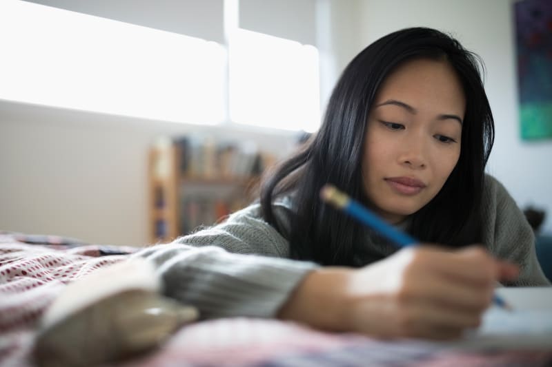 Young woman writing in a notebook.