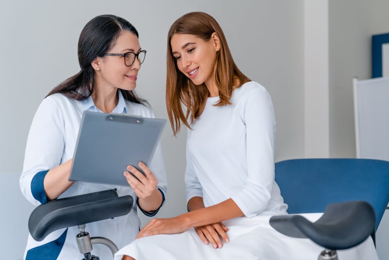 Young female talking with doctor at medical clinic.