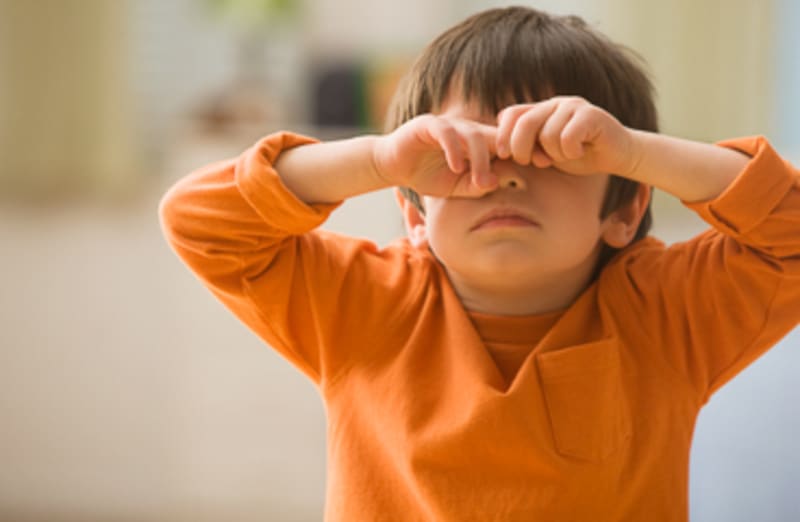 Child in discomfort with a headache.