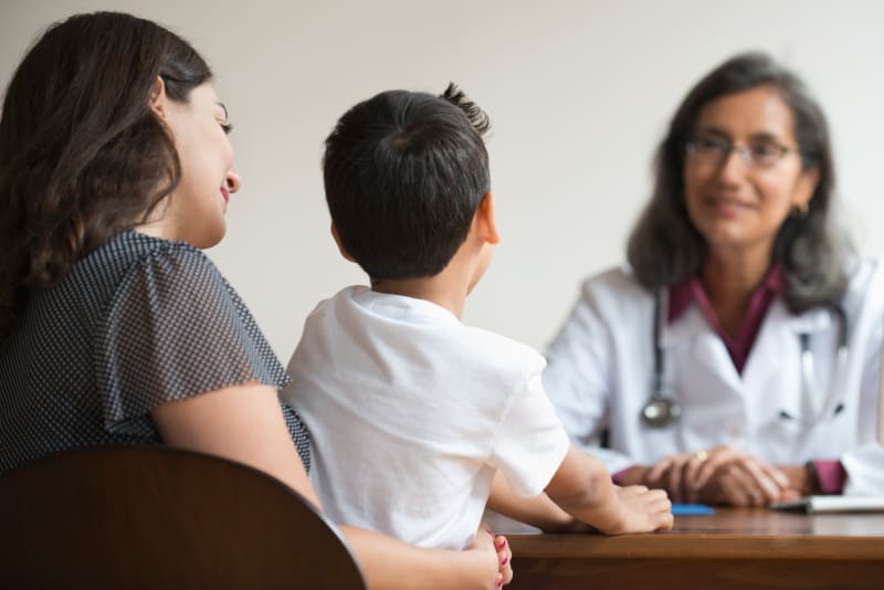 Mother and Son speaking with Doctor.