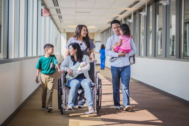 A family leaving the hospital with their newborn baby.