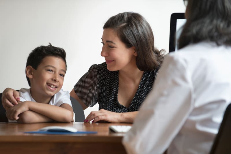 Parent and child talking with doctor at a clinic.