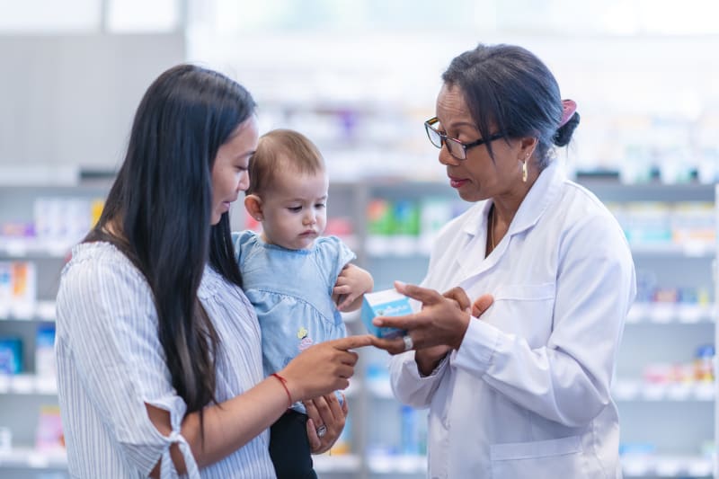 Pharmacist assisting Customer with her baby.
