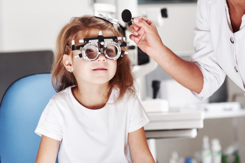 Young girl taking an eye test.