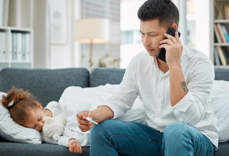 Father calling Doctor after taking sick Daughter's temperature.