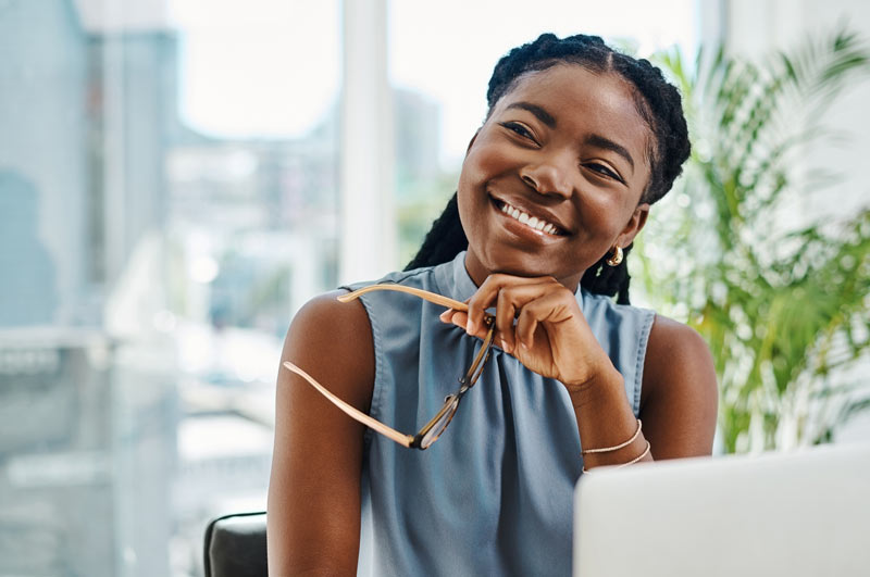 African American woman smiling in office with window in background