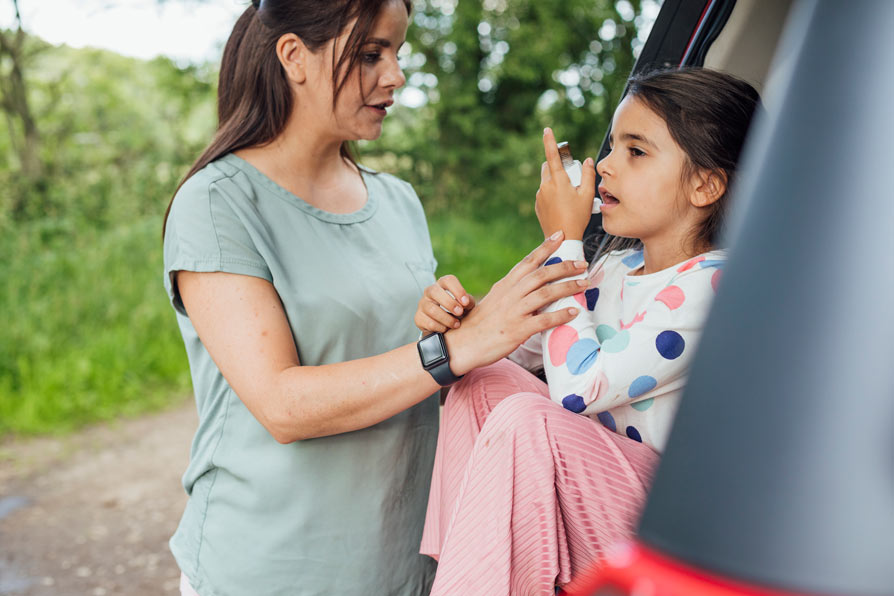 Mother helping daughter with asthma